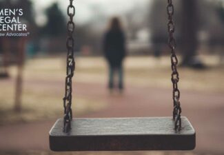 Image of an empty swing in a playground, with a distant parent in the background, representing loss of custody due to substance abuse.