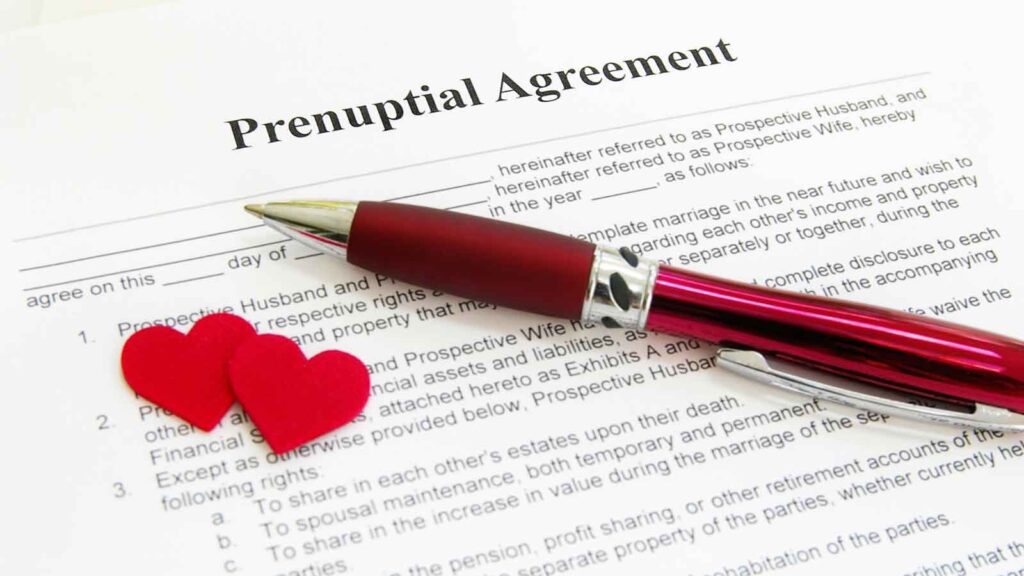 A close-up of a prenuptial agreement form placed on a wooden table.