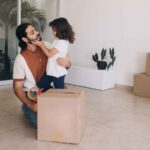 Dad and young child packing moving boxes together at home
