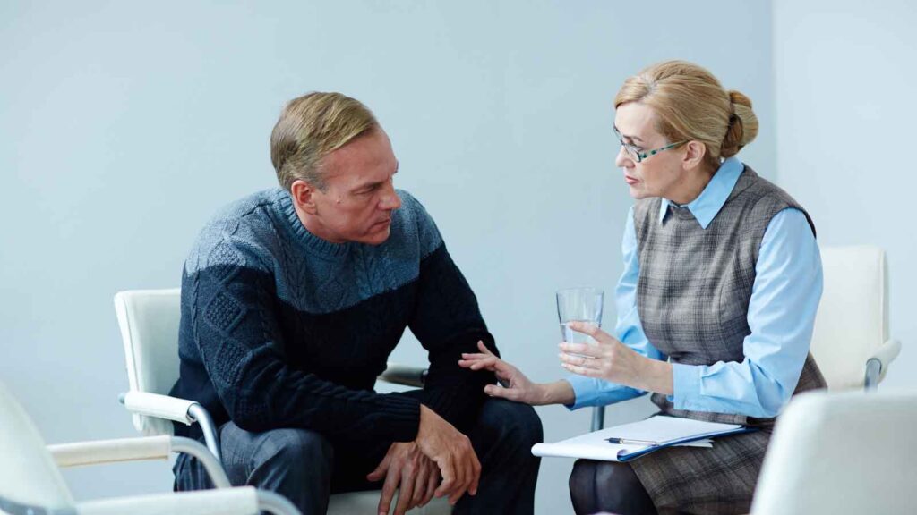 Male client discussing legal concerns with his attorney in an office