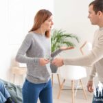 Man handing money to a woman with their child in the living room