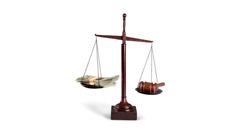 Close-up of a justice scale with a gavel on one side and cash on the other