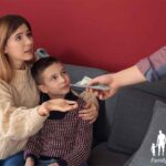 Man giving cash to his wife while sitting in their living room