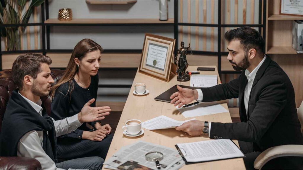 Husband and wife speaking with a lawyer during a consultation in a legal office 