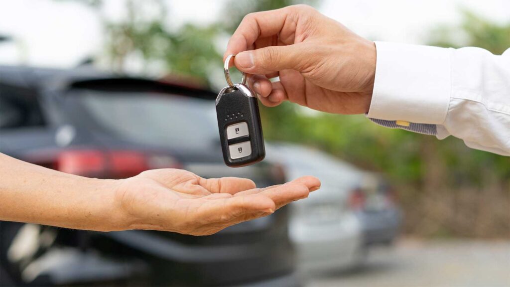  Close-up of one person handing over a car key to another