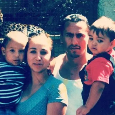 Photograph of a family of four, two adults and two young children, outdoors.