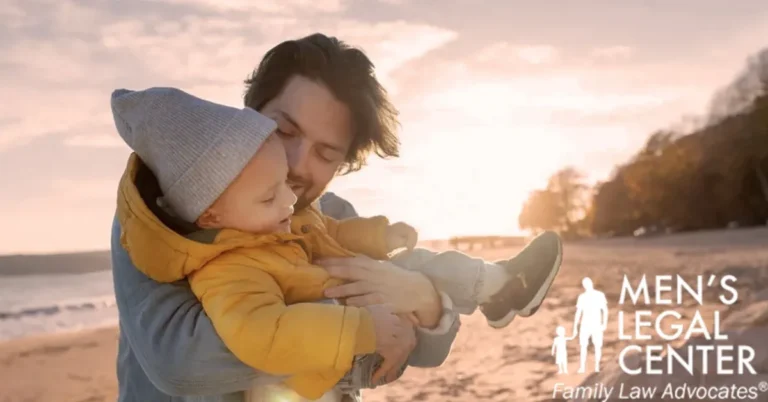 Man holding young child on beach at sunset, with "Men's Legal Center Family Law Advocates" text.