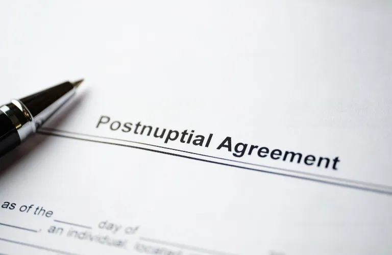 Close-up of a Postnuptial Agreement document with a black and silver pen on white paper.