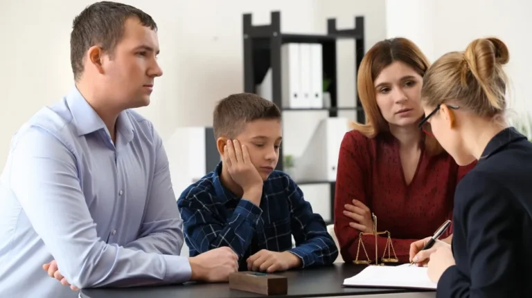 Professional consultation with a man, woman, and boy discussing legal matters with a female advisor.