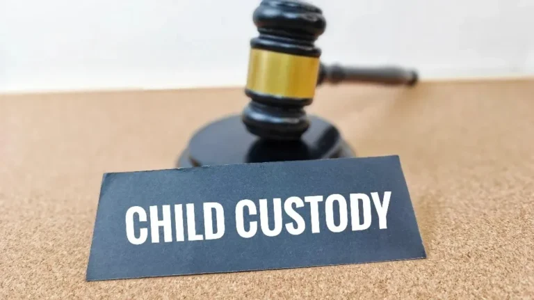 Black gavel with gold band behind a black sign displaying the text "CHILD CUSTODY" in white letters.